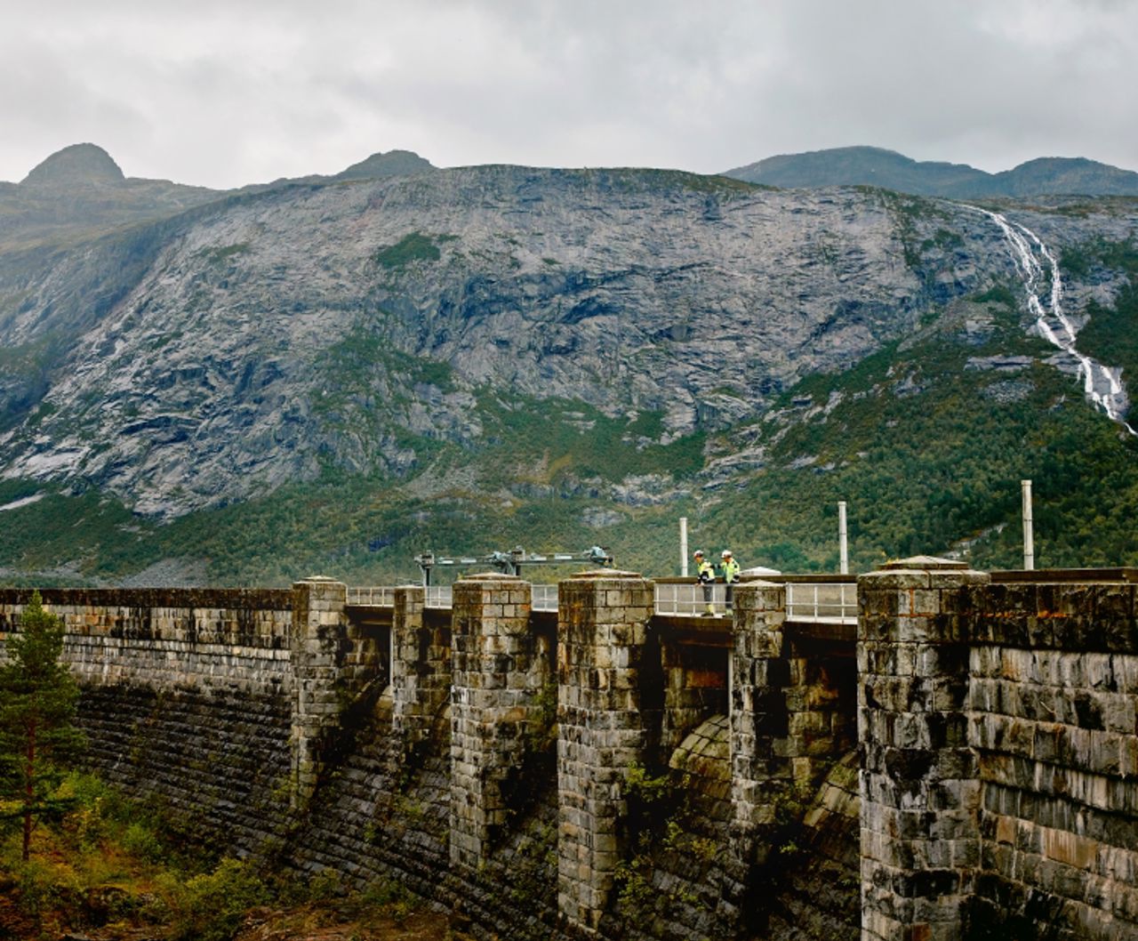 Two men standing on dam