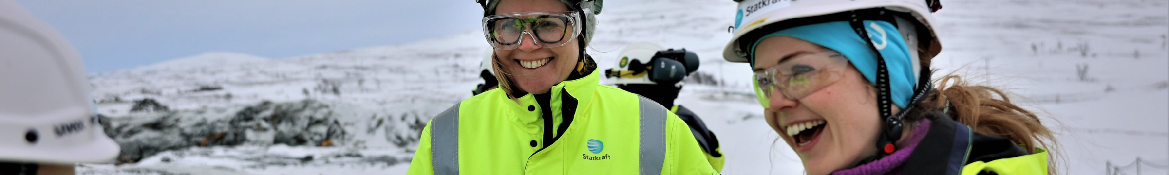 Two woman wearing safety gear and laughing at something